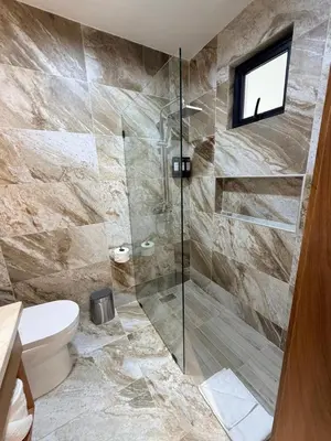 a bathroom with a toilet and a glass shower at PF Hotel in San Felipe de Puerto Plata