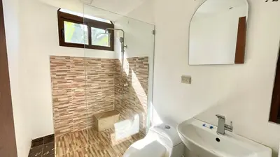 a bathroom with a shower and a toilet and a sink at Hideaway Studio - steps from Playa Encuentro at Cabarete in Cabarete