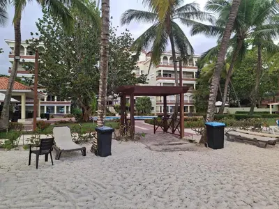 a park with a bench and a gazebo and palm trees at Apartment facing the Caribbean Sea, Juan Dolio Beach in Juan Dolio