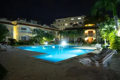 a swimming pool in front of a building at night at Star Villa Boca Chica in Boca Chica