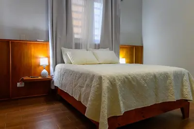 a bedroom with a large bed with a window at Spacious Family Home with Sea & Mountain Views in Puerto Plata in San Felipe de Puerto Plata