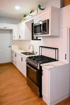 a white kitchen with a stove and a sink at Spacious Family Home with Sea & Mountain Views in Puerto Plata in San Felipe de Puerto Plata