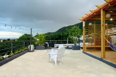 a couple of white chairs sitting on a patio at Spacious Family Home with Sea & Mountain Views in Puerto Plata in San Felipe de Puerto Plata