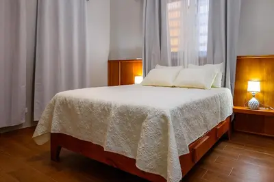 a bedroom with a bed with a white blanket and a window at Spacious Family Home with Sea & Mountain Views in Puerto Plata in San Felipe de Puerto Plata