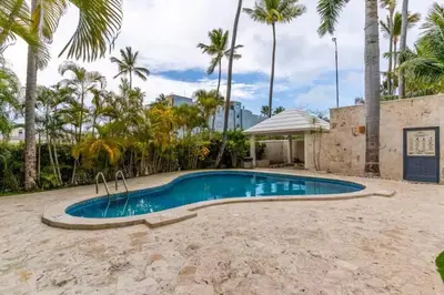 a swimming pool in a yard with palm trees at Cozy 2BR 2Bth walk 2 the beach Pool view Wi-Fi in Punta Cana