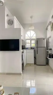 a large kitchen with white appliances and a large window at Cozy 2BR 2Bth walk 2 the beach Pool view Wi-Fi in Punta Cana