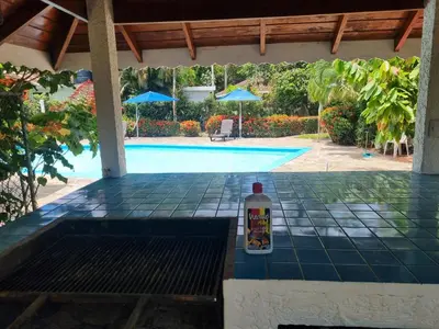 a bottle of drink sitting on a table next to a swimming pool at Sunset Paradise in Las Terrenas