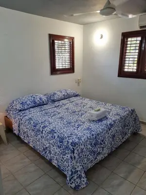a bedroom with a bed with a blue comforter at Sunset Paradise in Las Terrenas