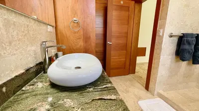 a bathroom with a white bowl sink in the floor at Luxury 2BR Villa - Beach Access and Elegant Design at Cabarete in Cabarete