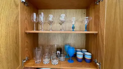 a cabinet with wine glasses and cups on shelves at Luxury 2BR Villa - Beach Access and Elegant Design at Cabarete in Cabarete