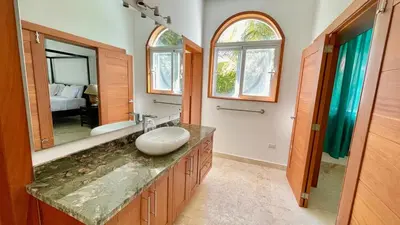 a bathroom with a sink and a large mirror at Luxury 2BR Villa - Beach Access and Elegant Design at Cabarete in Cabarete