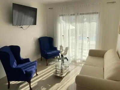 a living room with two blue chairs and a couch at Apartmento en Caleta, La Romana in La Romana