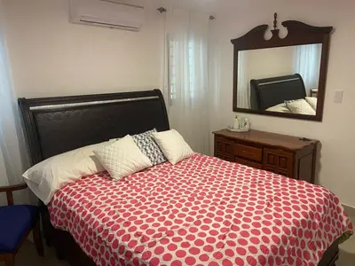 a bedroom with a bed with a large mirror at Apartmento en Caleta, La Romana in La Romana