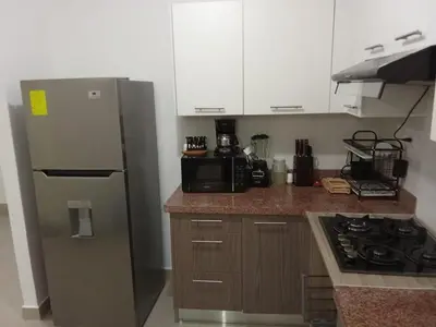 a small kitchen with a refrigerator and a stove at Apartmento en Caleta, La Romana in La Romana