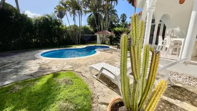 a cactus in front of a house with a swimming pool at 2BR villa & 1BR Guest House, Pool and Beach at Playa Encuentro, Cabarete in Cabarete