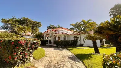 a white house with palm trees and bushes at 2BR villa & 1BR Guest House, Pool and Beach at Playa Encuentro, Cabarete in Cabarete