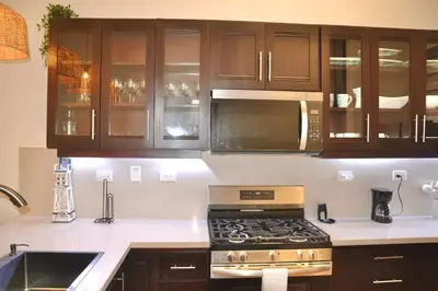 a kitchen with a stove and a microwave at Beachfront Hideaway 2BR Apartment at Playa Encuentro, Cabarete in Cabarete
