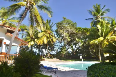 a resort with a swimming pool and palm trees at Beachfront Hideaway 2BR Apartment at Playa Encuentro, Cabarete in Cabarete