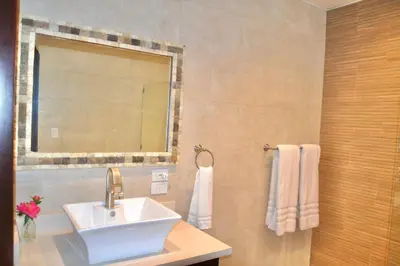 a bathroom with a sink and a mirror and towels at Beachfront Hideaway 2BR Apartment at Playa Encuentro, Cabarete in Cabarete