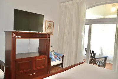 a bedroom with a flat screen tv on a dresser at Beachfront Hideaway 2BR Apartment at Playa Encuentro, Cabarete in Cabarete