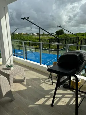 a chair on a balcony with a view of a pool at Apartamento Luxury Punta Cana in Punta Cana
