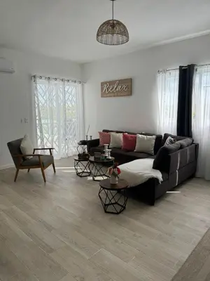 a living room with a couch and two tables at Apartamento Luxury Punta Cana in Punta Cana