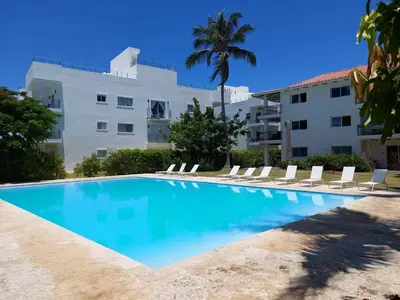 a swimming pool in front of a building at Apartamento Luxury Punta Cana in Punta Cana