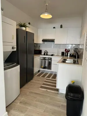 a kitchen with white cabinets and a black refrigerator at Apartamento Luxury Punta Cana in Punta Cana