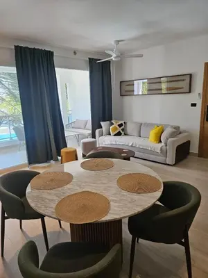 a living room with a table and chairs and a couch at Estrella Garden Antlia 201 Modern Apartment in La Laguna