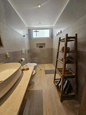 a bathroom with a sink and a toilet and a shelf at Estrella Garden Antlia 201 Modern Apartment in La Laguna