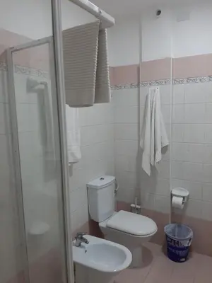 a small bathroom with a toilet and a shower at Palm Beach Resort in Boca Chica