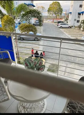a balcony with people walking down a street with palm trees at Filadelfia II in La Grúa