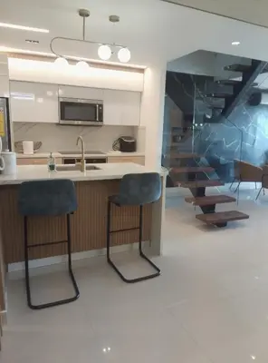 a kitchen with two bar stools and a sink at Torre Sky 01 M10-2 in Santo Domingo