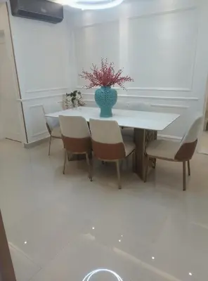 a table with chairs and a vase with flowers on it at Torre Sky 01 M10-2 in Santo Domingo