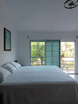 a white bedroom with a large white bed and windows at Villa can canet in Nizao
