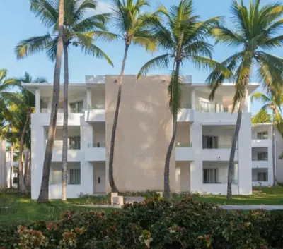 a building with palm trees in front of it at Caribe Deluxe Princess - All Inclusive in Punta Cana
