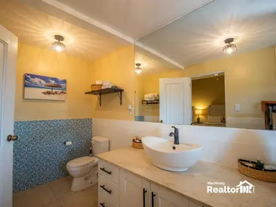 a bathroom with a sink and a toilet and a mirror at Casa Estrella, Where Relaxation Begins in Sosúa