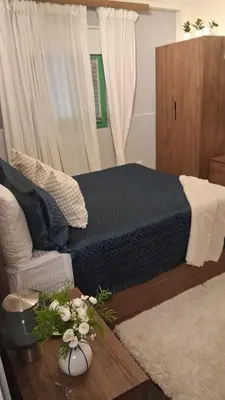 a bedroom with a bed and a table with flowers at Estancia Azul by Fusion Market in Santo Domingo