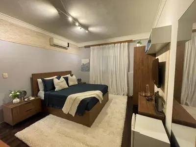 a bedroom with a bed and a television in it at Estancia Azul by Fusion Market in Santo Domingo