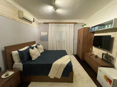 a bedroom with a bed and a television in it at Estancia Azul by Fusion Market in Santo Domingo