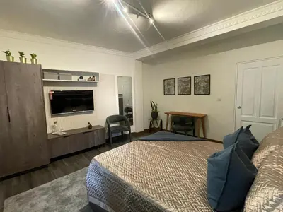 a bedroom with a bed and a flat screen tv at Estancia Azul by Fusion Market in Santo Domingo