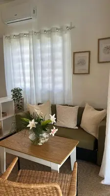 a living room with a couch and a table with flowers at Villa Turquesa En Dreams House - 5 pax, 2 min de la playa in Las Galeras