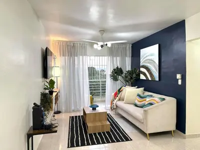 a living room with a white couch and a blue wall at Modern Penthouse Style Apt in Licey al Medio