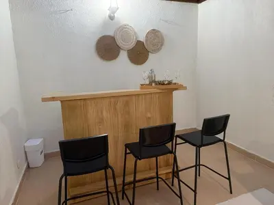 a bar with three chairs and a counter with plates on the wall at Modern Penthouse Style Apt in Licey al Medio
