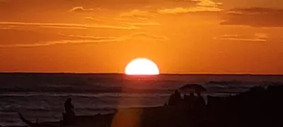 a sunset on the beach with the sun setting at Villas Caribe in Juan Dolio