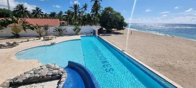 a swimming pool next to a beach at Villas Caribe in Juan Dolio