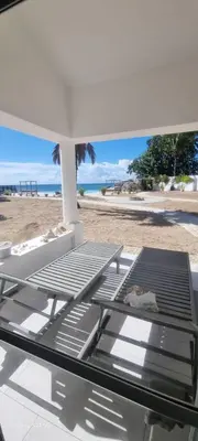 a bed on the beach with a view of the beach at Villas Caribe in Juan Dolio