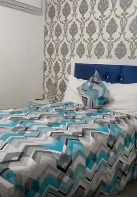 a bedroom with a bed with a colorful comforter at Residencial Mediterraneo III in Santiago de los Caballeros