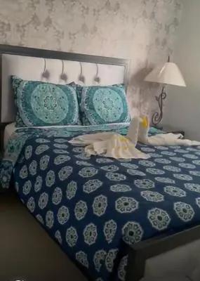 a blue and white bed with a dog laying on it at Residencial Mediterraneo III in Santiago de los Caballeros