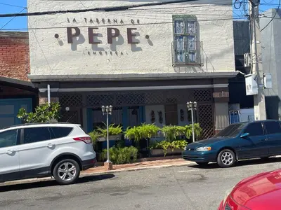 two cars parked in front of a store at FredyGreenHouse in Santiago de los Caballeros